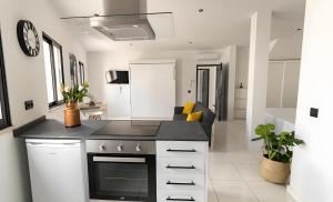 a kitchen with a black counter top and a living room at Mi Casa Es Su Casa Nº4 in Albufeira +3 photos