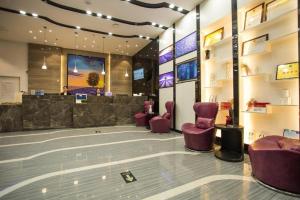 a lobby with purple chairs and a waiting area at Lavande Hotels Heze Changjiang Road Wanda Plaza in Zhaolou