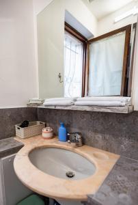 a bathroom with a sink and a mirror at Torre Cà Emo - Monolocale "L'Antico portico" in Vittorio Veneto +4 photos