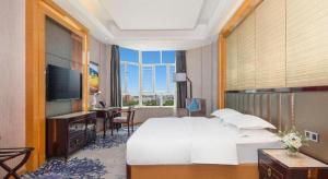 Uma cama ou camas num quarto em Metropolo Hotel Yining Development Zone Hanma Building
