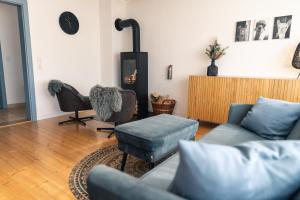 a living room with a couch and a chair at Landhaus Paco Ferienhaus für 12 Personen mit Alpakas, Sauna & Kamin in Blaufelden