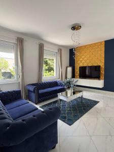 een woonkamer met blauwe banken en een tv bij Dorothy 2 in Siófok