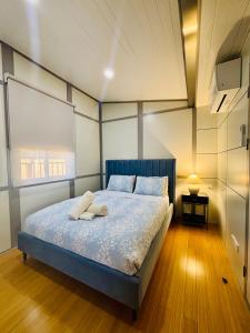 a bedroom with a blue bed with two towels on it at Norwesta Lifestyle Park in Carnarvon