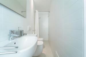 a white bathroom with a sink and a toilet at Casa Nova in Alghero +26 photos