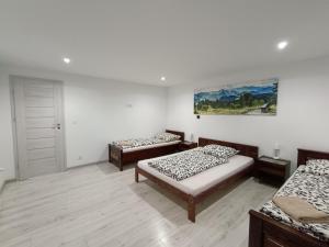 a room with two beds and a painting on the wall at Kowolove in Bańska Wyżna