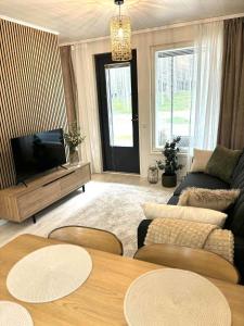 a living room with a couch and a tv at Luhtitalon päätyhuoneisto saunalla - Liinavaatteet,pyyhkeet ja loppusiivous sisältyvät aina majoituksen hintaan in Kalajoki