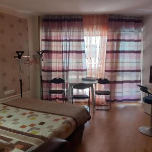 a bedroom with a bed and a table and chairs at RUBIN-2 in Pomorie