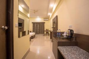 Un pasillo de una habitación de hotel con un dormitorio. en Hotel Sravasti Residency, en Katra