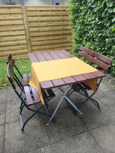 a picnic table and two chairs sitting next to each other at Apartmenthaus Sonnenschein Top3 in Dornbirn