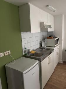 a small kitchen with a sink and a microwave at Petite chatelaine in Herbeumont +5 photos