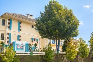 a house with a tree in front of it at Pousada Piano Piano in Campos do Jordão