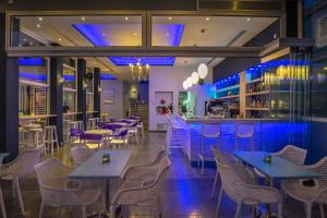 a restaurant with tables and chairs and a bar at Must Boutique Hotel & Restaurant in Kanali