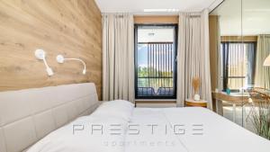 sypialnia z dużym białym łóżkiem i biurkiem w obiekcie Prestige Apartments Botanica w Gdańsku