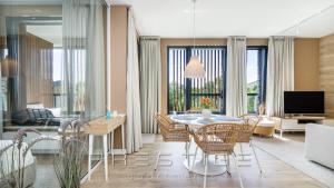 salon ze stołem, krzesłami i telewizorem w obiekcie Prestige Apartments Botanica w Gdańsku