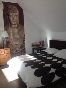 1 dormitorio con una gran estatua de una cabeza en la pared en Serenity, en Le Landin