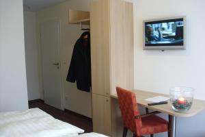 Zimmer mit einem Schreibtisch und einem Tisch mit einem TV in der Unterkunft Gasthaus Wiemann-Sander in Bad Iburg