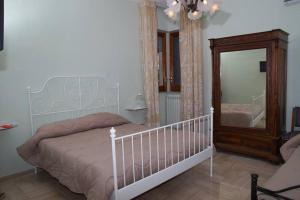 a bedroom with a white bed and a mirror at B&B La Bougainvillea in Andria