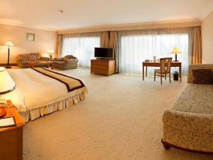 a hotel room with a bed and a desk at Dalian Zhongshan Hotel in Dalian