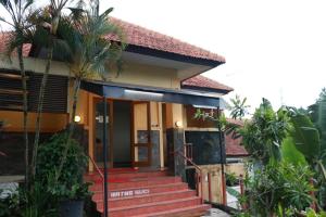 a house with a red staircase in front of it at Pondok Jatim Park Hotel & Cafe in Batu