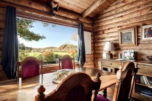 Paw PawStunning Secluded Log Cabin with River Access in Paw Paw, Maryland的带桌子和大窗户的餐厅