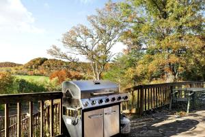 Paw PawStunning Secluded Log Cabin with River Access in Paw Paw, Maryland的木栅栏旁的烧烤架