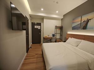 ein Schlafzimmer mit einem großen weißen Bett und einem Schreibtisch in der Unterkunft Karasky Hotel in Simpang Ampat