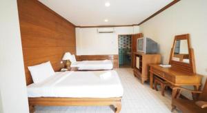 Un dormitorio con una cama grande y un televisor. en Fah Place Hotel, en Nan