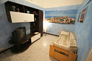 インペリアにあるCasa Agostinoのベッド1台とテレビが備わる小さな客室です。