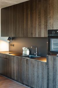 eine Küche mit Spüle und Mikrowelle in der Unterkunft SVENCELE DUNES Marių g 31-1 in Svenele