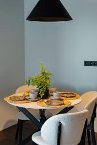 einen Esstisch mit einer Topfpflanze darauf in der Unterkunft SVENCELE DUNES Marių g 31-1 in Svenele
