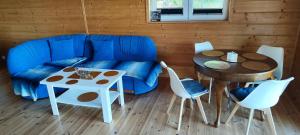 a living room with a blue couch and a table at Przy jeziorze in Kaliska Kośierskie