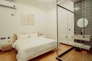 ZhangshanyingBeijing Meet the Mountain Boutique Guesthouse的带床和玻璃淋浴间的卧室