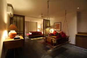 The Sky Imperial Aarivaa Luxury HomeStay في راجكوت: غرفة مع غرفة معيشة مع أريكة وسرير
