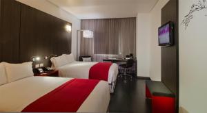 Postel nebo postele na pokoji v ubytování Ramada Encore by Wyndham Guadalajara Sur + 37 fotografií