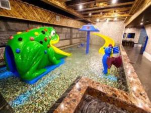 a room with a pool of water with a playground at Zhangjiajie Xiangfu International Hot Springs Hotel in Zhangjiajie
