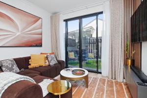 a living room with a couch and a large window at Quiet Suburban Escape Near Shops & Dining in Gepps Cross