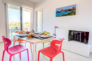 ein Esszimmer mit einem Tisch und 4 Stühlen in der Unterkunft Appartamenti Sud Est in Marina di Ragusa