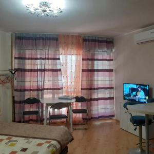 a bedroom with a table and chairs and a tv at RUBIN-2 in Pomorie