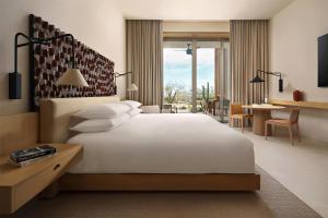 a bedroom with a large white bed and a desk at Park Hyatt Los Cabos At Cabo Del Sol in Cabo San Lucas +31 photos