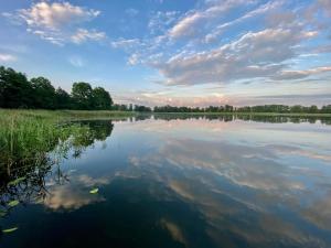a view of a lake with clouds in the sky at Domek nad jeziorem Romantyka in Giże +5 photos