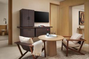 a living room with a table and a tv at Park Hyatt Los Cabos At Cabo Del Sol in Cabo San Lucas