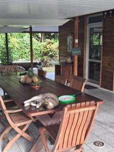 a cat sleeping on a wooden table on a patio at Tema'e Beach House in Temae
