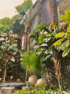 a house with palm trees in front of a yard at Huern Che Ta One Hotel in Phrae