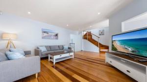 un salon avec une grande télévision à écran plat dans l'établissement Sea Spray- Private Pool, Beach, Table Tennis, à Entrance