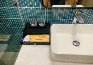 a bathroom with a sink and two glasses on a counter at Thành phố Flamingo Hải Tiến City Ibiza Resort Biển 5 Sao KS 21 tang -SeaNest 609 in Thanh Hóa