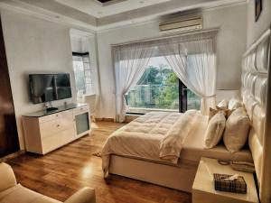 a bedroom with a large bed and a large window at The G8 in Noida