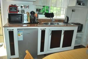 cocina con encimera, microondas y fregadero en kim luxury home, en Kampala 14 fotos más