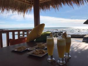 a table with two glasses of beer and some food at Double G Resort Anyer in Carita