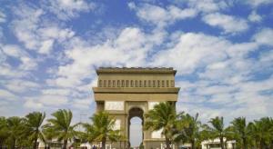 Una torre de reloj con palmeras y un cielo nublado en ZUZU Simpang Lima, en Semarang