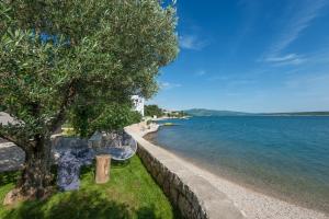 een tafel en stoelen naast een waterlichaam bij House Maruna in Maslenica